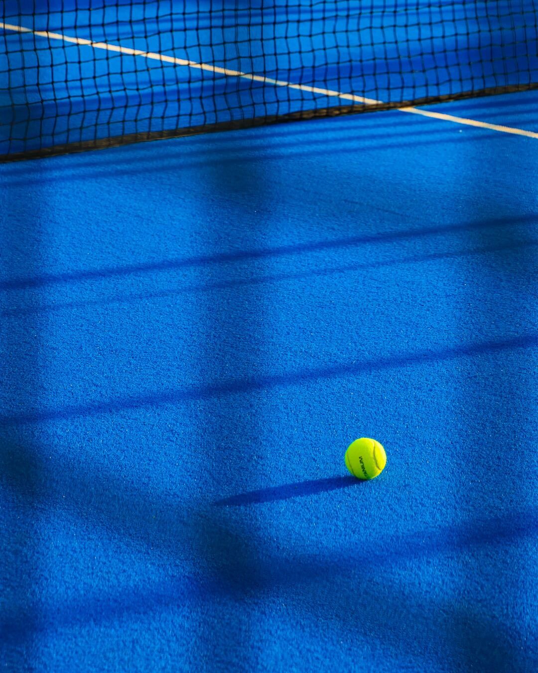 Padelball auf einem blauen Court