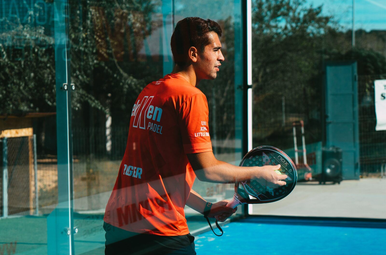 Padelspieler hält seinen Schläger vor dem Netz